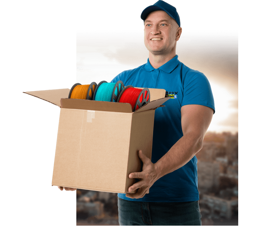 Man standing with box in hands and smiling.